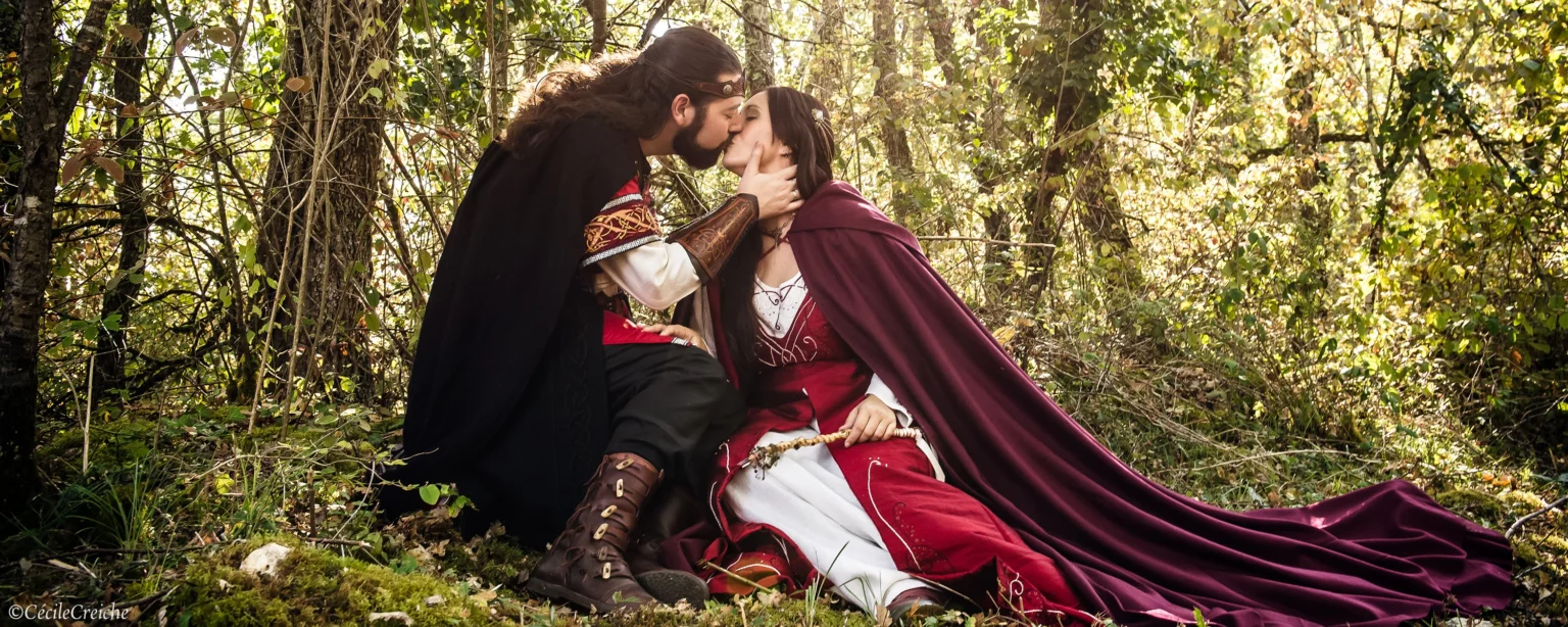 2 mariés dans uen foret entrain de s'embrasser lors d'un mariage médiévale