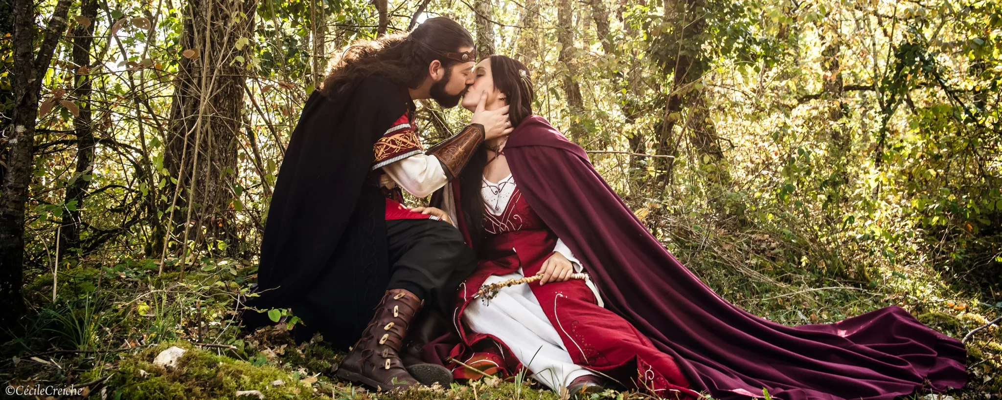 2 mariés dans uen foret entrain de s'embrasser lors d'un mariage médiévale
