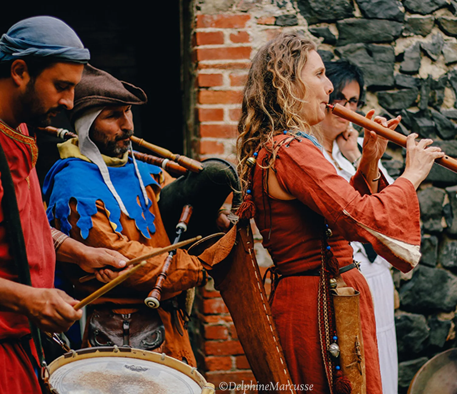 Une femme jouant de la musique en costume lors d'une cérémonie de mariage médiévale.